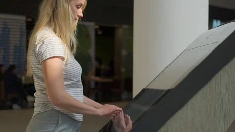 Woman using interactive touchscreen display at mall - scrolling and touching. Stock Footage 107383319