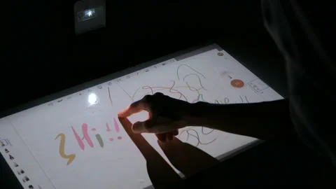 Woman using interactive touchscreen projector display for drawing at exhibition Stock Footage 94498101