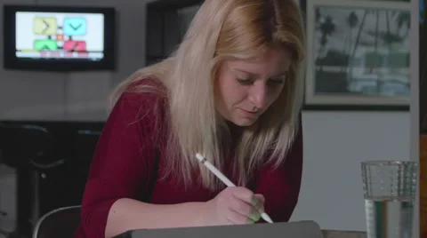 Woman Using iPad with TV on in Background Vídeos de archivo 59728928