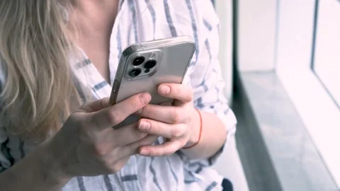 Woman using iPhone 12 pro max smartphone pressing finger, typing text, reading Stock Footage 205254007