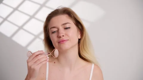Woman using jade roller on face, cheek, jaw, neck, with delicate gesture Stock-Footage 269007115