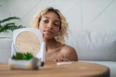 Woman using jade roller looking in mirror at home.Copy space beauty and skin Stock Photos