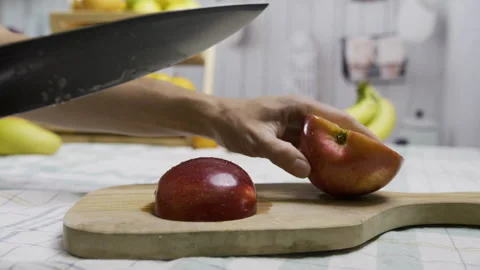 Woman using knife to cut delicious apple into slices on cutting board in Stock Footage 341229595