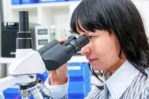 Woman using a Lab microscope Stock Photos
