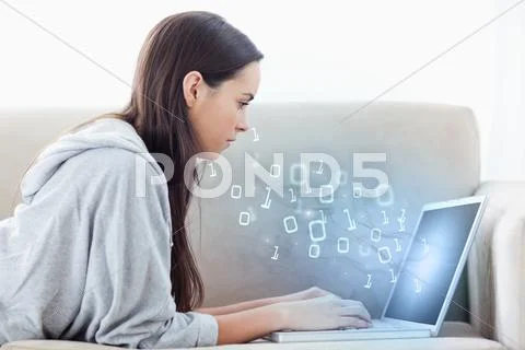 Woman using laptop with binary codes floating over Stock Photos