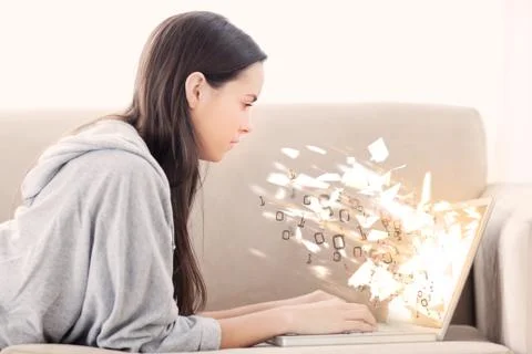 Woman using laptop with binary codes exploding over Stock Photos