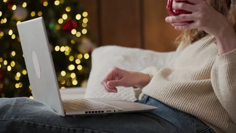 Woman using laptop with coffee during Christmas at home Stock Footage 340489977