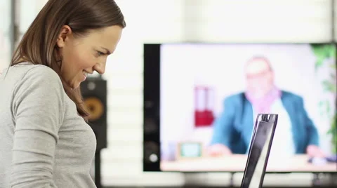 Woman using laptop computer and watching TV HD Stock Footage 40503412