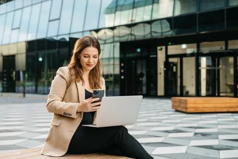 Woman using laptop computer sitting on bench Stock Photos