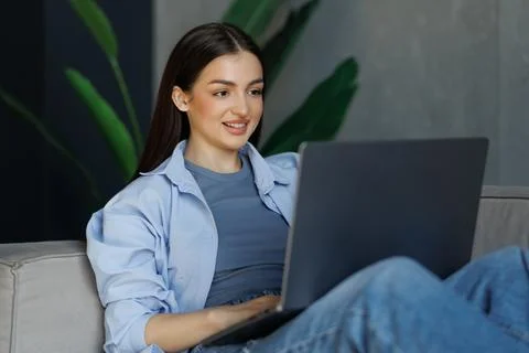Woman using laptop computer, working at home. Fotos Stock