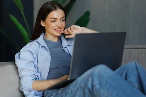 Woman using laptop computer, working at home. Stock Photos
