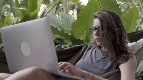 Woman using laptop in hammock Video stock 84841938