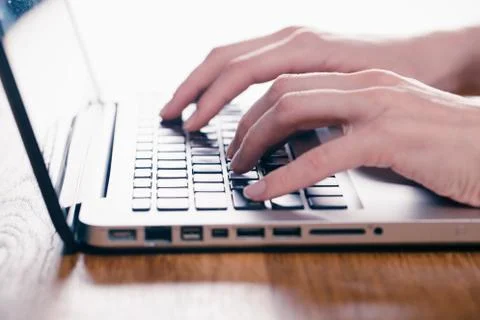 Woman using laptop on light table, closeup Stock Photos
