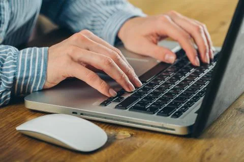 Woman using laptop on light table, closeup Stock Photos