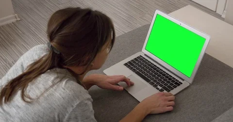 Woman using Laptop Notebook computer with Green Screen lying on sofa Stock Footage 75065964