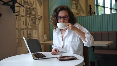 Woman using laptop pc computer, drink coffee, works in coffee shop, cafe Stock Footage 302155779