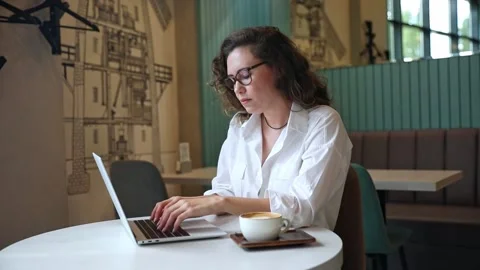 Woman using laptop pc computer, drink coffee, works in coffee shop, cafe Stock Footage 302155783