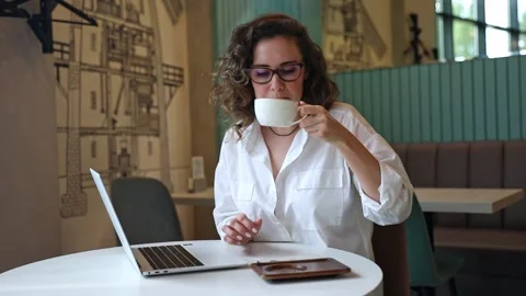 Woman using laptop pc computer, drink coffee, works in coffee shop, cafe Stock Footage 302155789