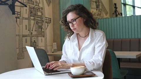 Woman using laptop pc computer, drink coffee, works in coffee shop, cafe Stock Footage 302155817