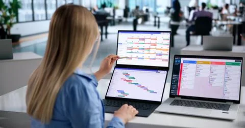 Woman Using Laptop To Plan Team Schedule And Check Project Progress. Stock Photos