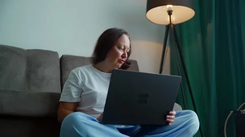 Woman Using Laptop Sitting on Couch in Modern Living Room 库存影片 339632017