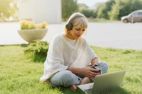 Woman using laptop sitting on the grass Stock Photos