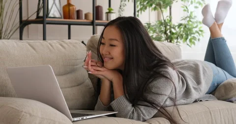 Woman using laptop on sofa Stock Footage 145295669