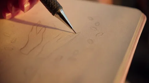 Woman using left hand to draw logo sketch in notebook on street in the evening Stockbeeldmateriaal 285314297