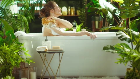 Woman Using Loofah on Shoulder in a Bubble Bath Stock Footage 335171046