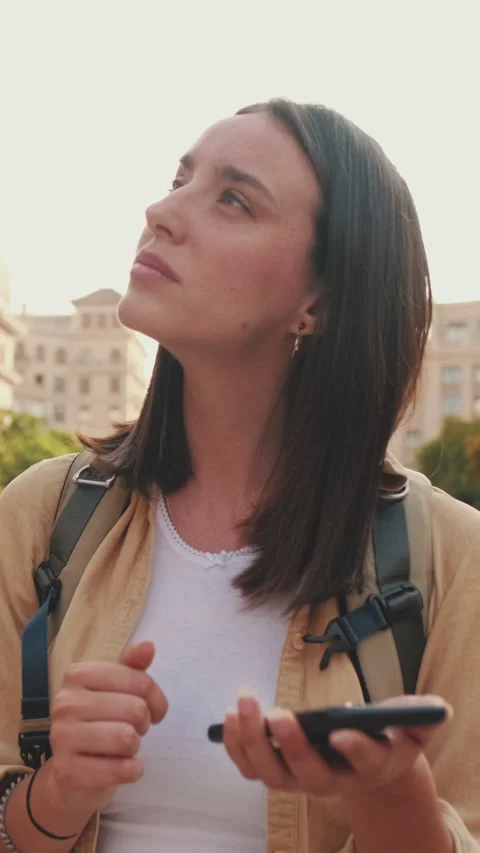 Woman using map app while standing on the square of an old european city Stock Footage 252030855