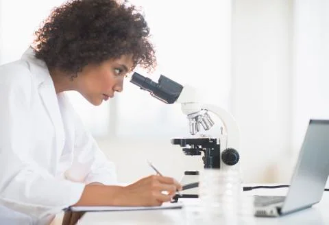 Woman using microscope in laboratory Foto stock