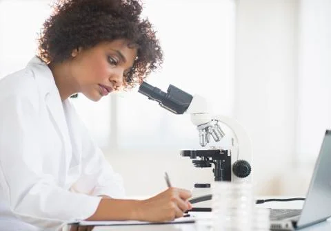 Woman using microscope in laboratory Foto stock