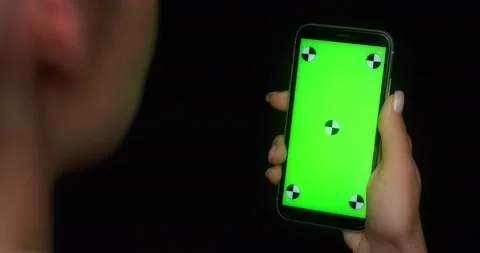 Woman using mobile app on green screen phone, pokes at the center of the screen Stock Footage 177241892
