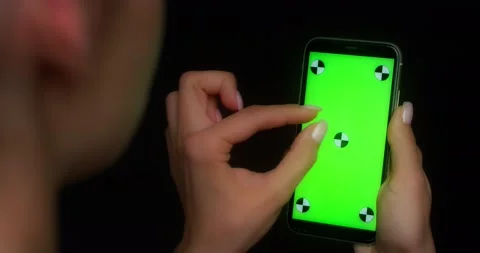 Woman using mobile app on green screen phone, makes a two-finger zoom gesture Stock Footage 177776298