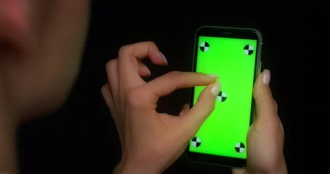 Woman using mobile app on green screen phone, makes a two-finger zoom gesture Stock Footage 177776930
