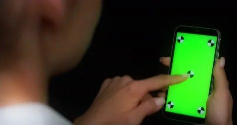 Woman using mobile app on green screen phone, swipes down Stock Footage 177777254