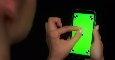 Woman using mobile app on green screen phone, makes a two-finger zoom gesture Stock Footage 177777576