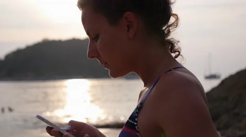 Woman Using Mobile Phone on Beach by Sea at Sunset Vídeos de archivo 59173274