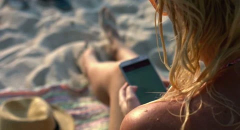 Woman Using a Mobile Phone at the Beach Stock Footage 61157739