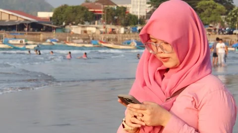 Woman using mobile phone at the beach Video stock 342087628