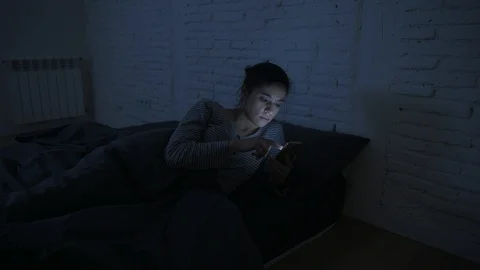 Woman using mobile phone in bed at night Stock Footage 87318266