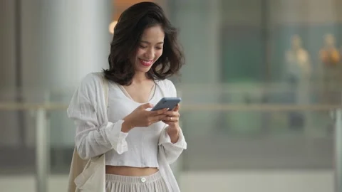 Woman using mobile phone walking in the shopping mall in the urban city Stock Footage 160713872