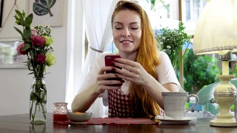 Woman using mobile phone while drinking tea. Stock Footage 88692310