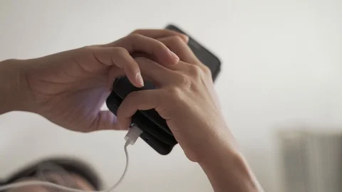 Woman using mobile phone while charging Stock Footage 118238642