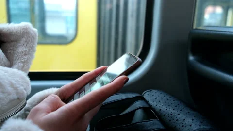 Woman using mobile phone while sitting in public transport Stock Footage 218578241