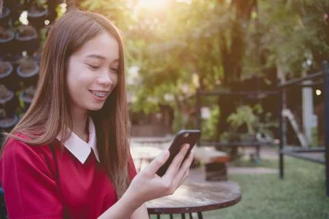 Woman using mobile phone while stand in the park Stock Photos