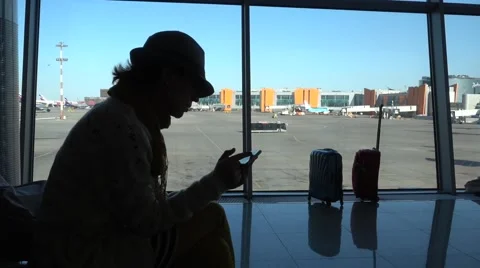 Woman using mobile smart phone at the airport Stock Footage 62483643