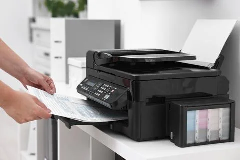 Woman using modern printer at workplace indoors, closeup Foto stock