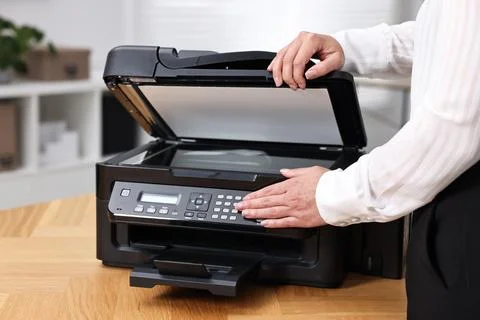Woman using modern printer at workplace indoors, closeup Foto stock