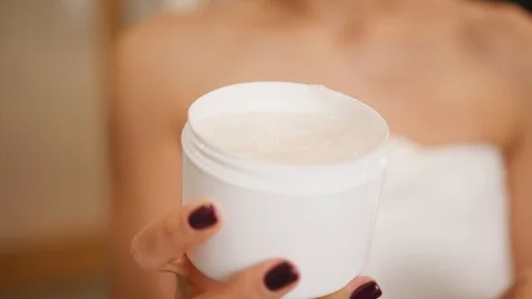Woman using moisturizing cream on her face, skincare routine Video stock 101484642